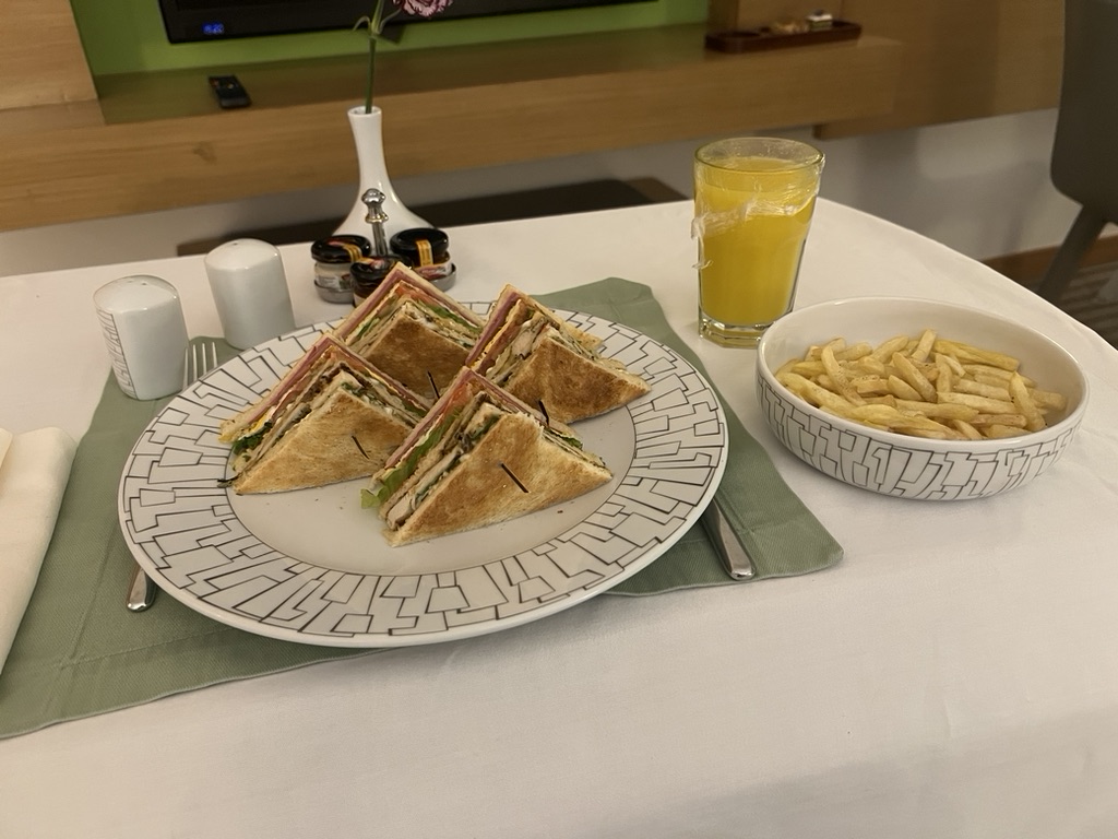 4E0B421F-2DD4-47FA-943D-E04418622168_1_105_c room service table with a club sandwich, french fries and an orange juice